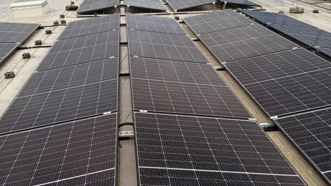 Mehrere Solarpaneele nebeneinander auf dem Dach des Familienzentrums installiert.