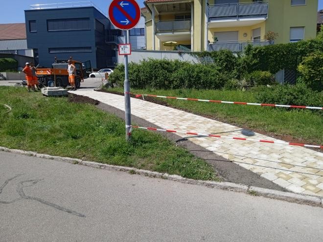 Neu gepflasterter Weg, Bauhofmitarbeiter im Hintergrund.