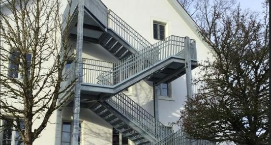 Edelstahl-Fluchttreppe an der Fassade des Gebäudes "Alte Schule".