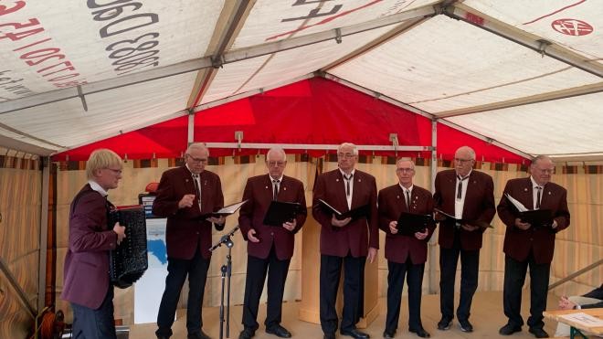 Die 7 Herren des Gesangvereins in einheitlicher festlicher Kleidung auf der Bühne im Festzelt.