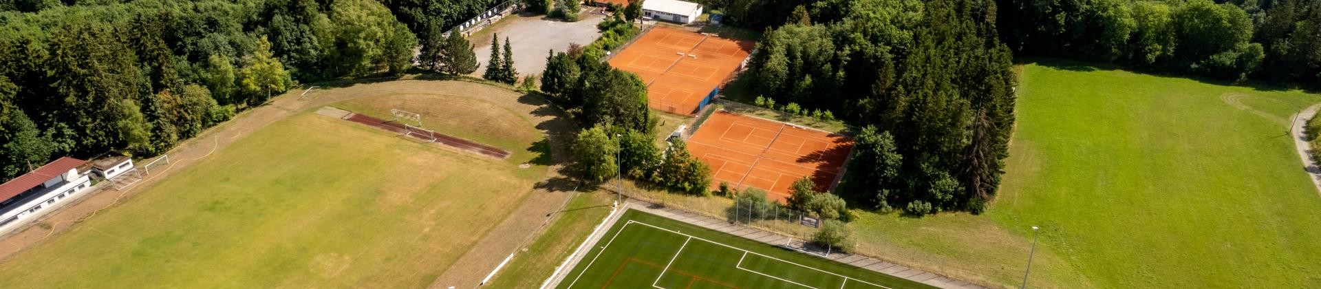 Luftbildaufnahme, zeigt Sportplatz und Tennisplatz der Gemeinde.