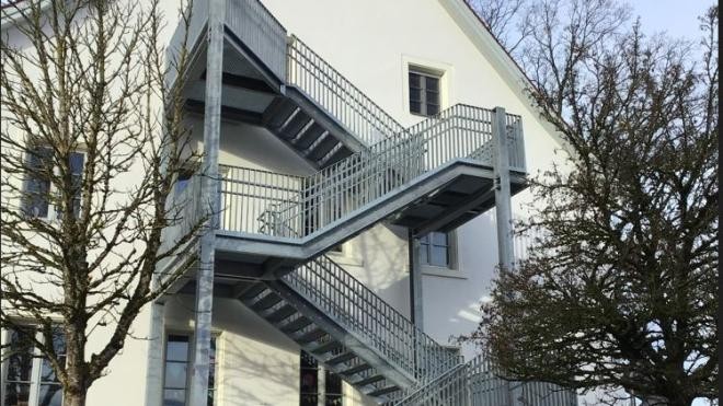 Edelstahl-Fluchttreppe an der Fassade des Gebäudes "Alte Schule".