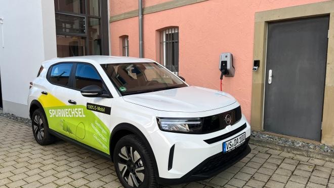 Der neue Opel Frontera geparkt am Hintereingang des Rathauses. Auf dem weißen Auto steht in grün- und gelb Spurwechsel.