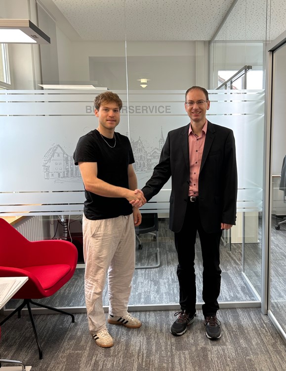 Links der Sportler Lukas Krauß er schüttelt die Hand von Bürgermeister Torben Dorn rechts auf dem Bild.