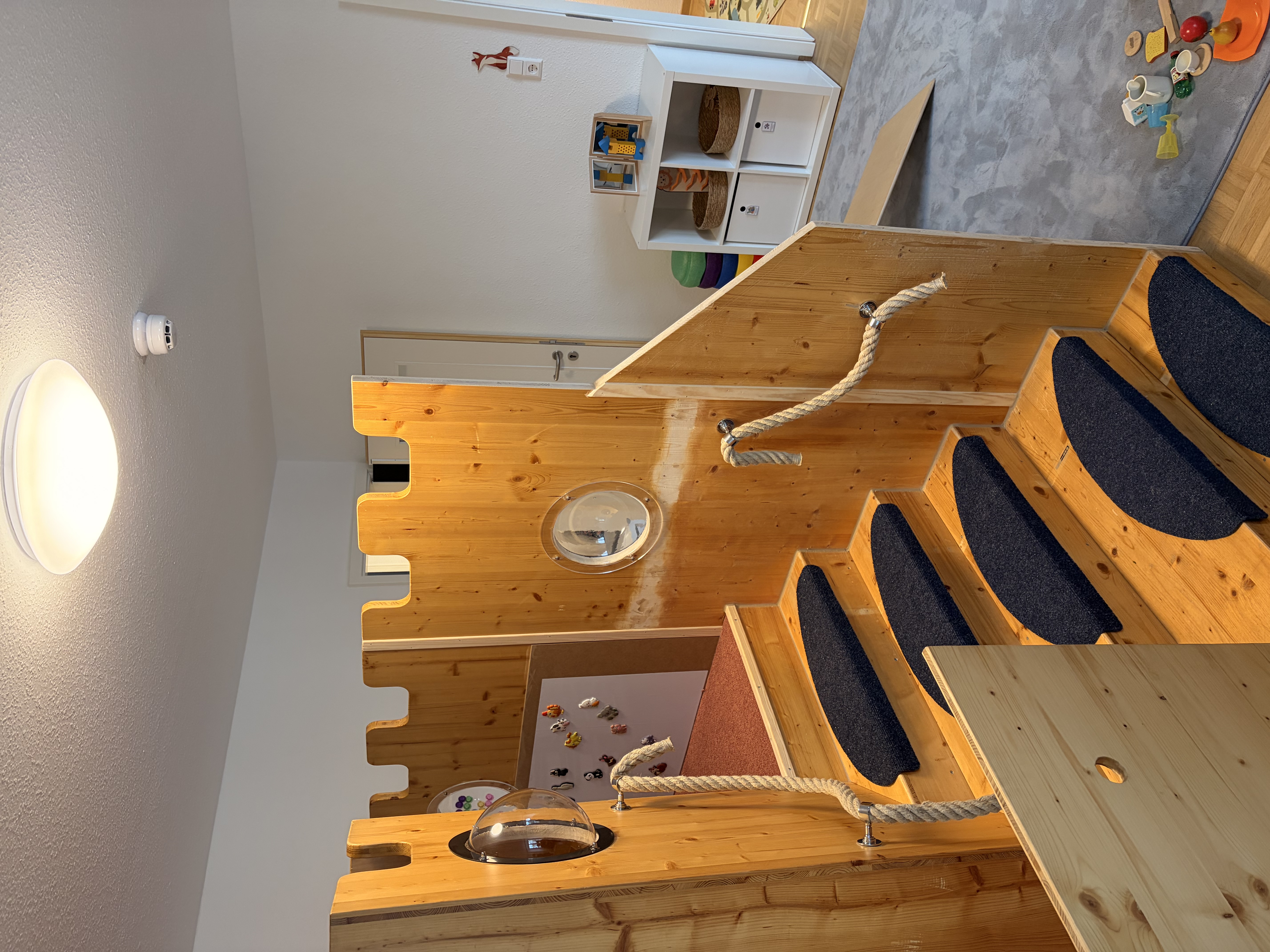 Spielzimmer der Kindertagespflege, eine Holztreppe als Spielvorrichtung.