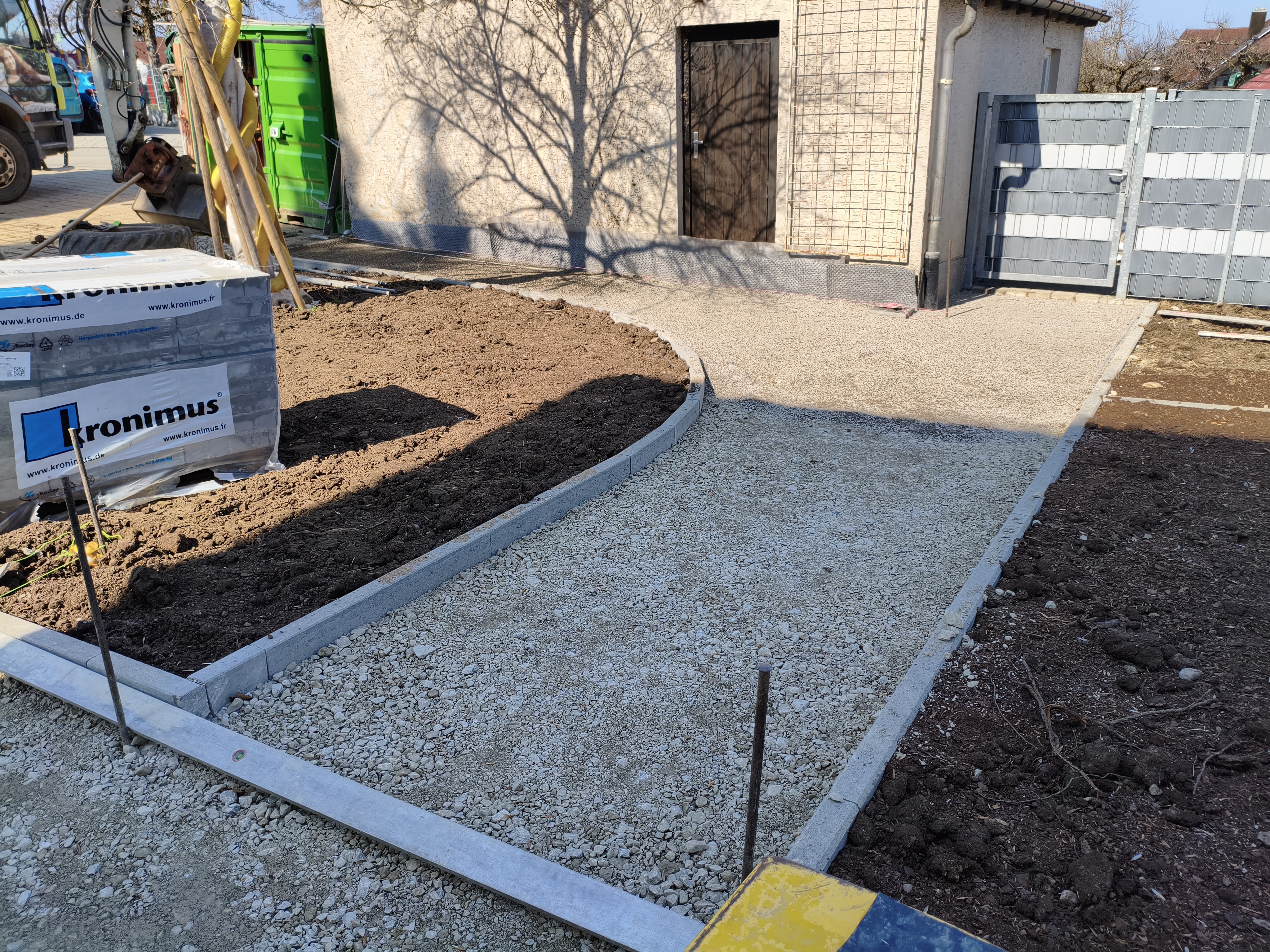 Die Entstehung des Müllabstellplatzes, auch hier werden Beete angelegt und Pflastersteine verlegt.