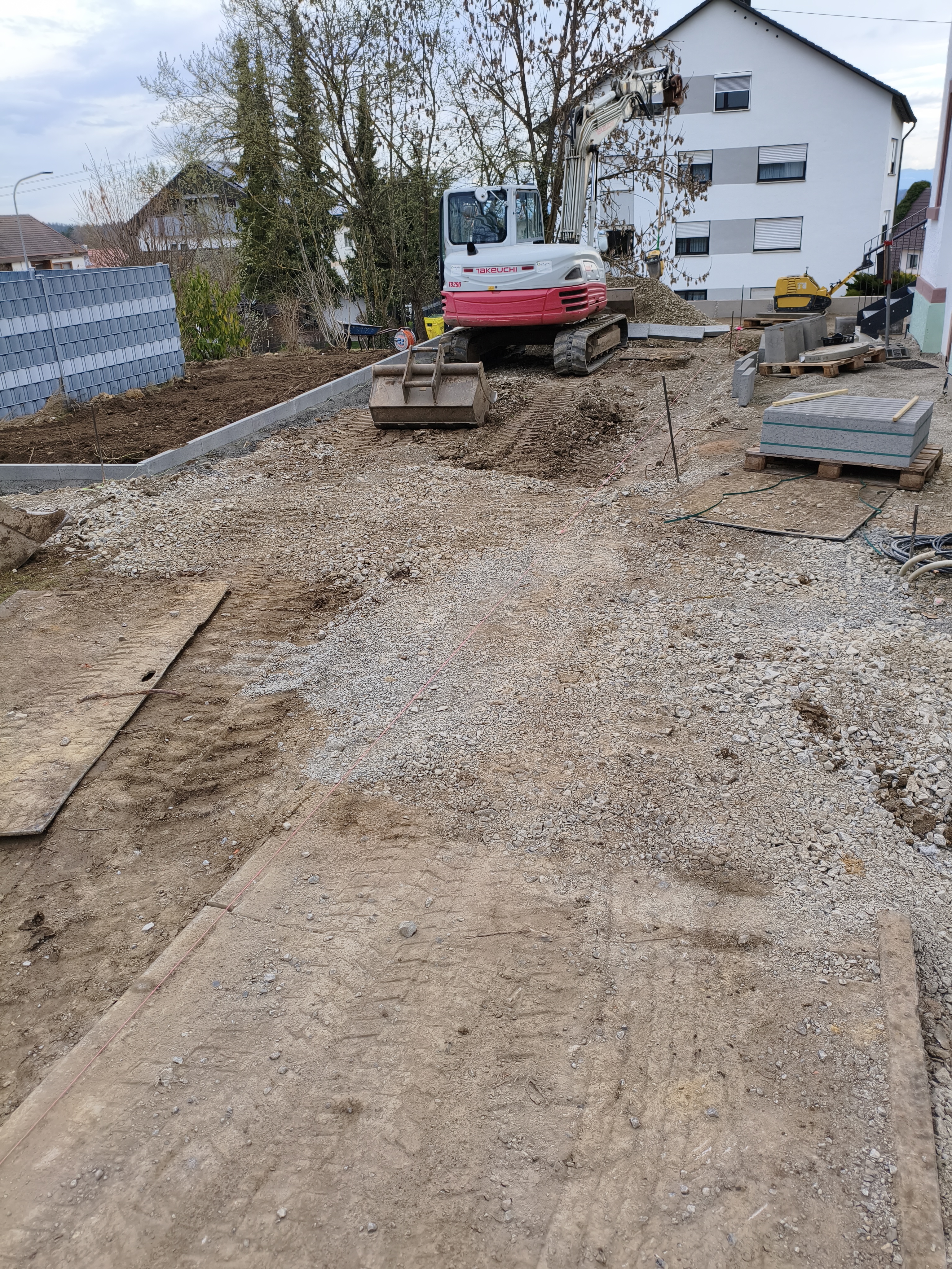 Bagger im Garten des Pfarrhauses, er macht den Boden eben.