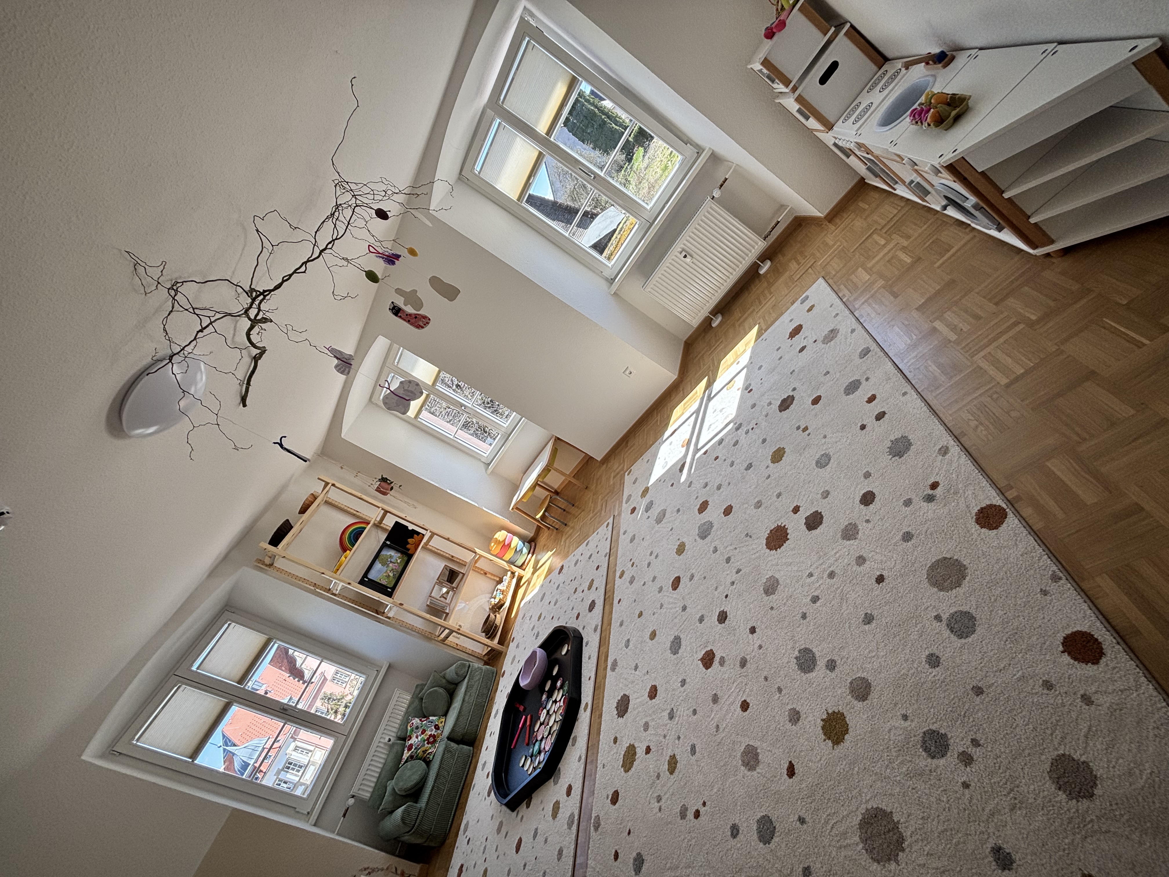 Lichtdurchfluteter Altbauraum mit kindgerechter Einrichtung, schlicht aber auch etwas bunt.