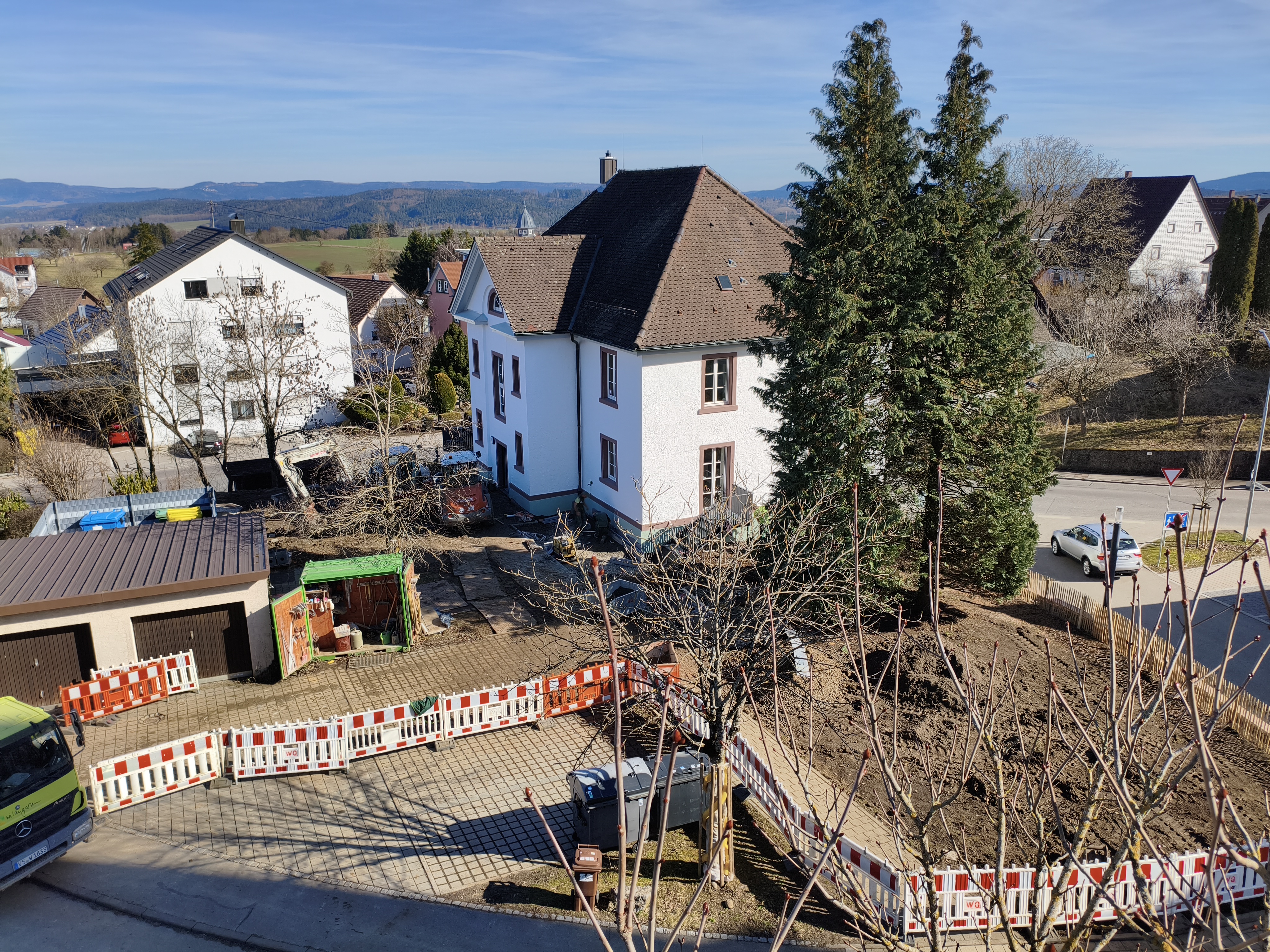Blick von oben auf die Gartenanlage, mit Bauzaun eingezäunter Garten des Pfarrhauses.